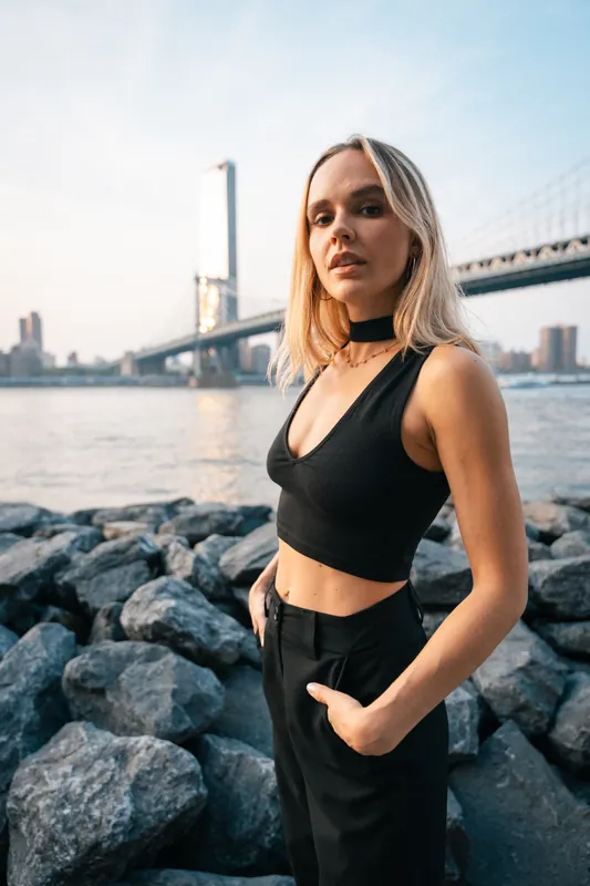 Black crop top and trousers on rocks below the Manhattan Bridge