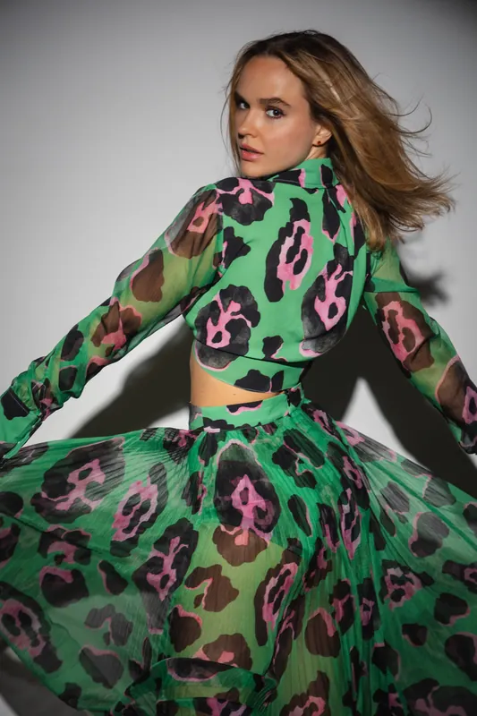Green and pink leopard print two piece, hair in motion, grey backdrop