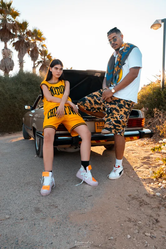 Streetwear look beside the open trunk of a vintage Mercedes at golden hour, Israel