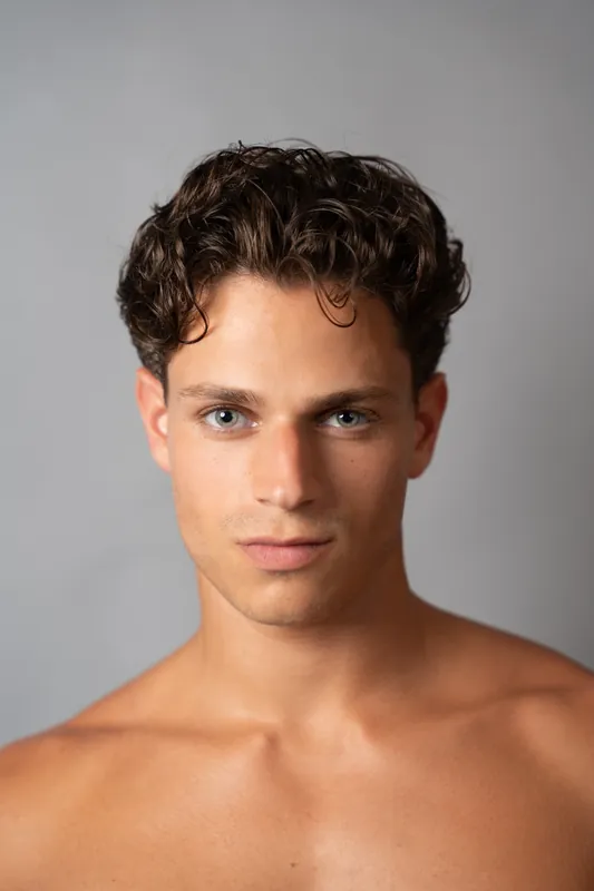 Close headshot on grey, direct gaze
