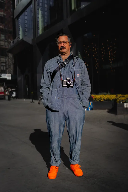 Man in workwear overalls in hard Midtown light