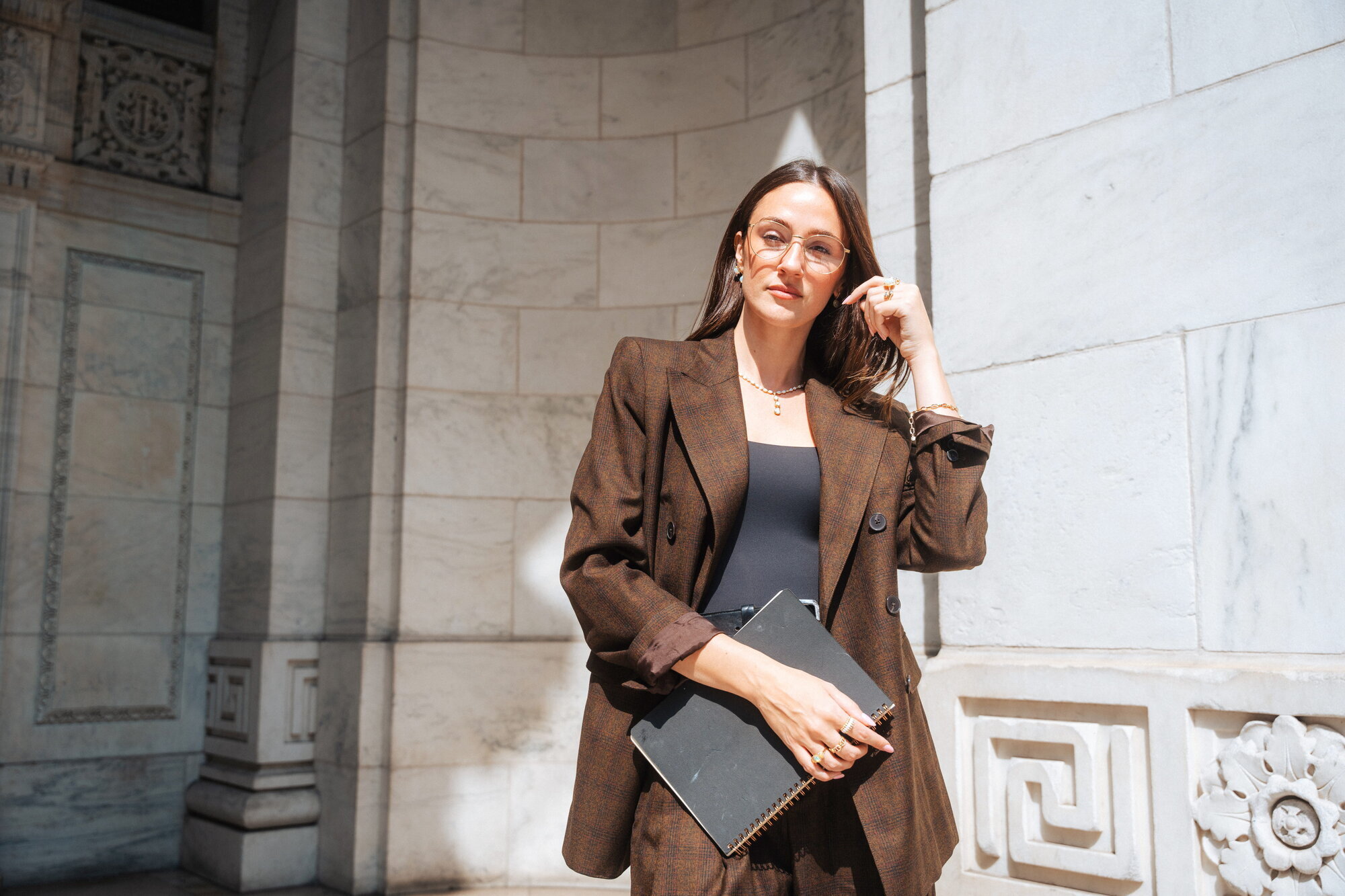 Frame from an EFFY Jewelry campaign shot by NYC director of photography Emanuel Rahmanan — model in dappled sunlight against carved marble architecture
