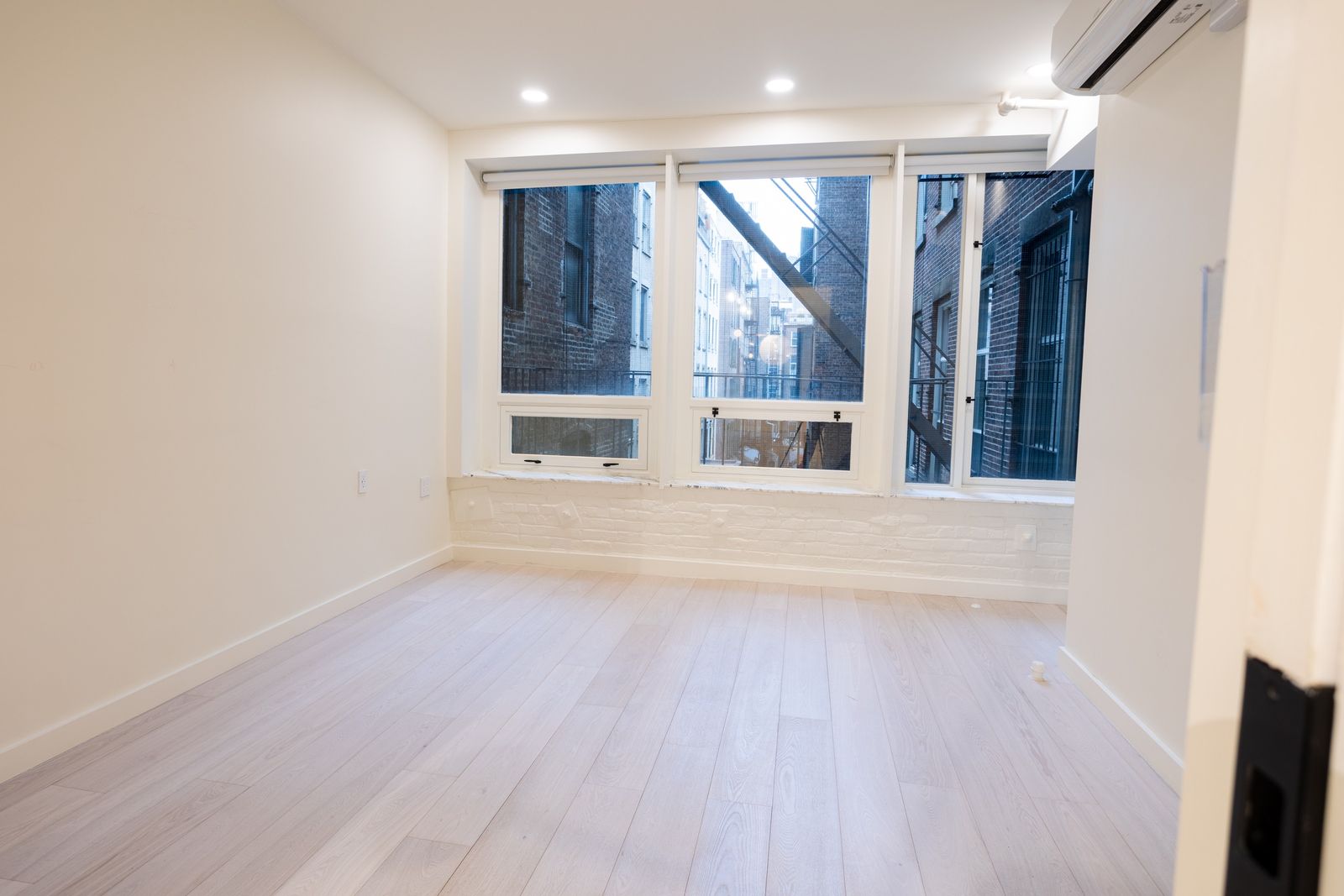 Before: a loft bedroom with tall windows, empty